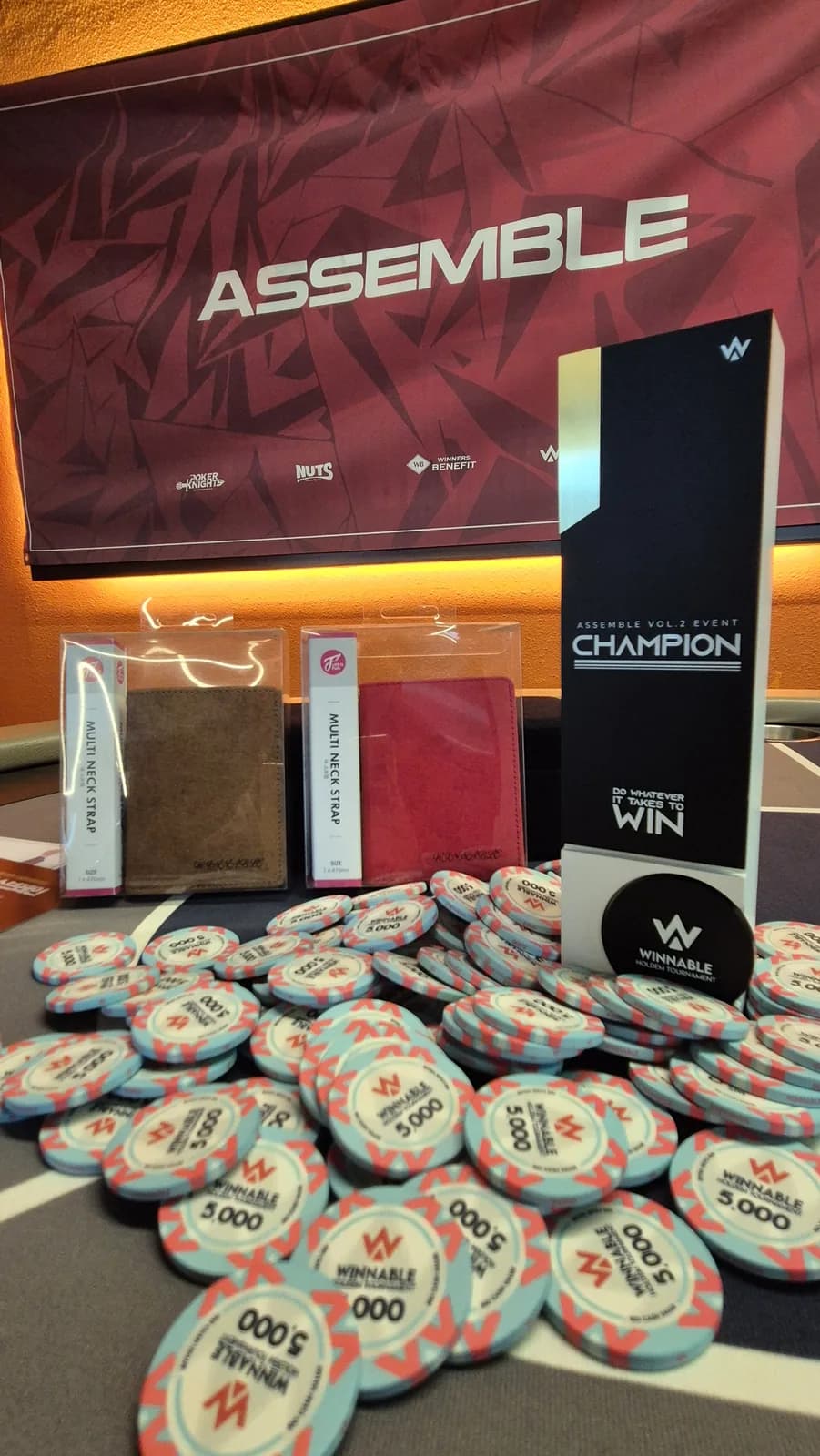 The champion trophy and chip stacks before the ASSEMBLE banner